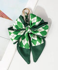 Green and white checkered bow keychain on a light background argyle