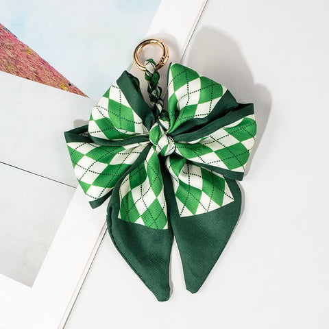 Green and white checkered bow keychain on a light background argyle