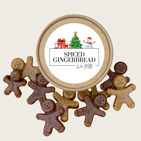 A round wooden gift tin labeled 'Spiced Gingerbread' with a white center label and small holiday illustration, surrounded by several gingerbread-shaped cookie wax melts in light brown, medium brown, and dark chocolate tones on a light beige background.