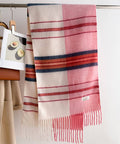 Gradient Plaid scarf with pink, red, and beige colors hanging on a rack.