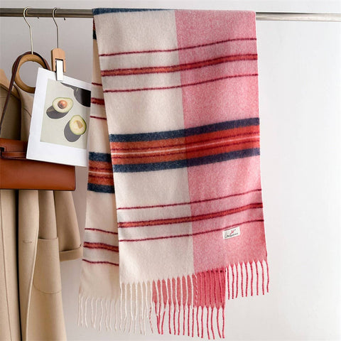 Gradient Plaid scarf with pink, red, and beige colors hanging on a rack.