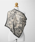Scarf with black and white pattern on a mannequin against a white background