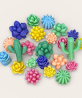 A collection of colorful miniature succulent and cactus wax melts arranged on a light beige background.