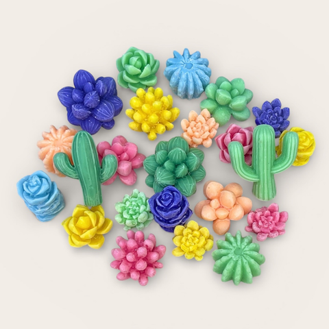 A collection of colorful miniature succulent and cactus wax melts arranged on a light beige background.