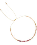 Bracelet with pink and gold beads on a white background