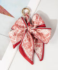 Red and white patterned bow keychain on a white background