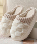 Pair of beige slippers with fuzzy texture on a soft surface