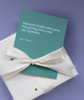 the gift of snark this season greeting card pale blue on green background tied with cream bow