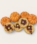 A set of miniature autumn-themed craft wax melts featuring five small orange pumpkins and five round waffle cookies topped with dark brown syrup and yellow butter details, arranged on a light beige background.