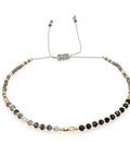 Bracelet with black and gold beads on a white background