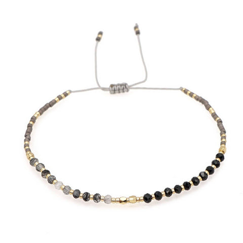 Bracelet with black and gold beads on a white background