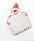 sticky note pad shaped like holiday elf holding large card. elf is dressed in red on green background board