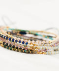 Stack of colorful beaded bracelets on a light background