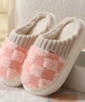 Pair of pink and beige slippers on a soft surface