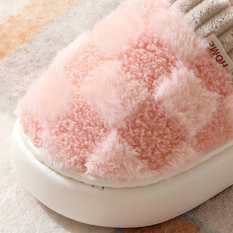 Close-up of a pink fluffy pet bed with a brand label on a soft surface.