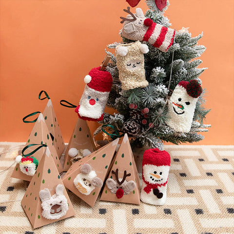 Decorative Christmas tree with animal-themed ornaments and gift boxes on a patterned surface.