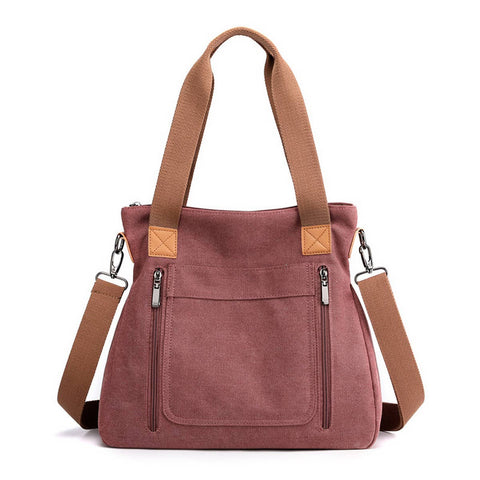 Dusty rose handbag with brown straps on a white background